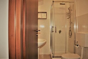 Ein Badezimmer mit Duschkabine, Waschbecken und Toilette.