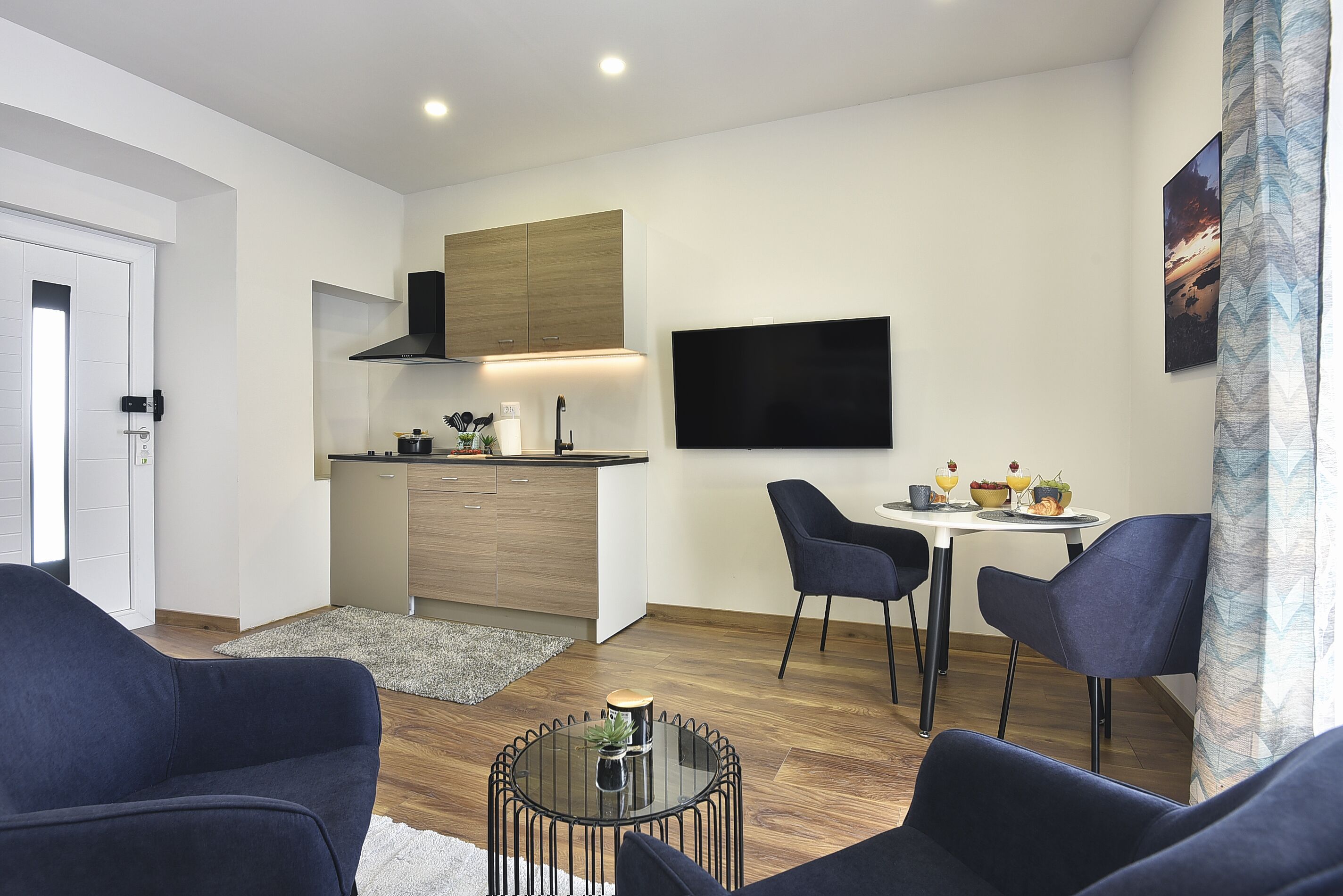 Una sala de estar moderna con un sofá, una mesa de centro y un comedor con sillas y una mesa.