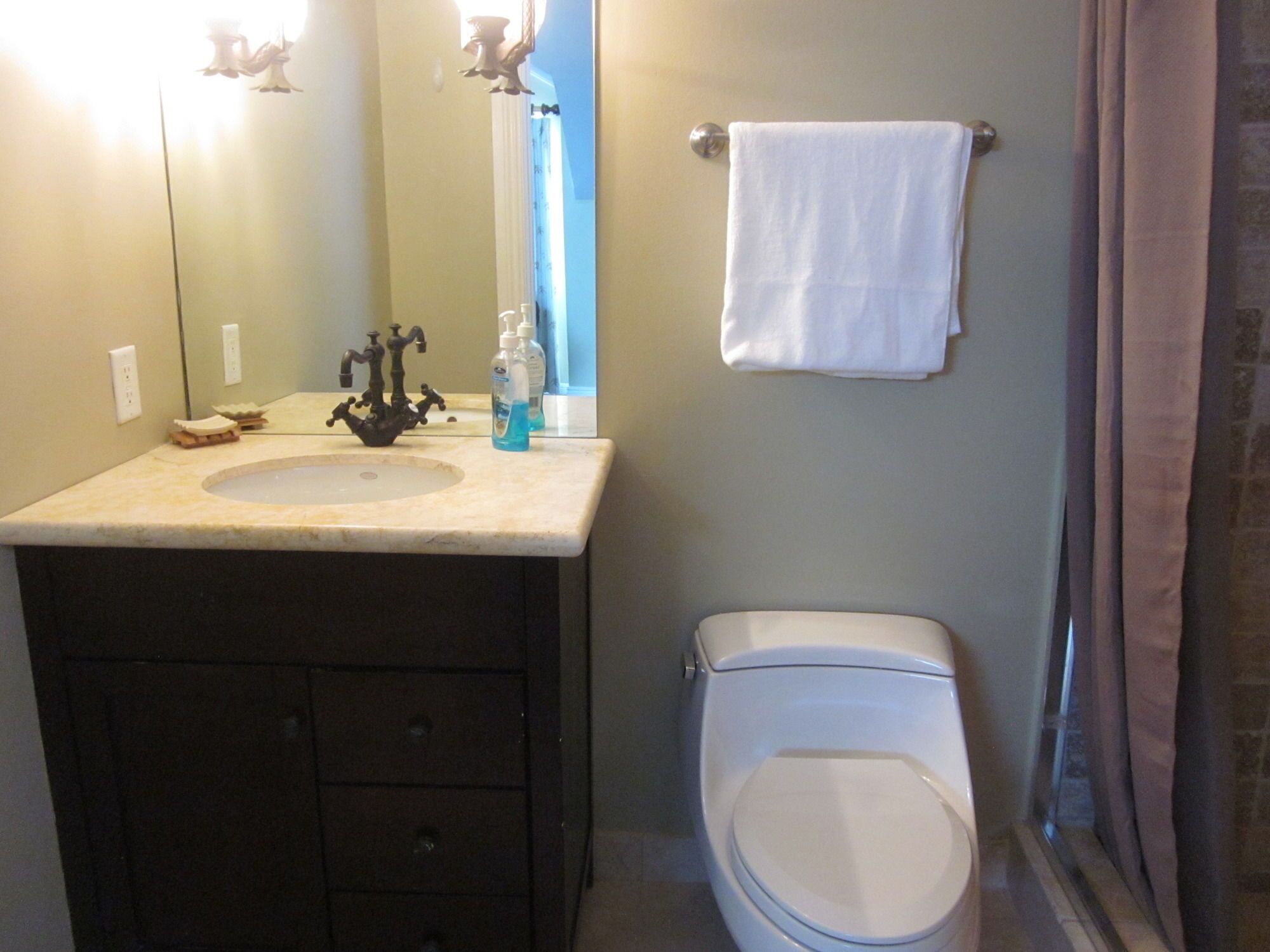 A bathroom with a sink, mirror, and toilet.