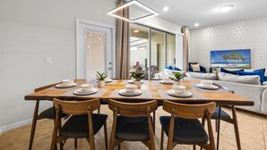 A dining area with a wooden table set for four, surrounded by chairs. - 10% off Fall 2026 5-Bedroom Luxury Retreat w/ Modern Updates & Premium Amenities (Davenport)