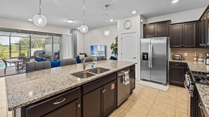 A modern kitchen with granite countertops, stainless steel appliances, and dark cabinetry. - 10% off Fall 2026 5-Bedroom Luxury Retreat w/ Modern Updates & Premium Amenities (Davenport)