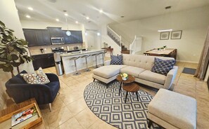 A living room with a sectional sofa, a coffee table, and a patterned rug.