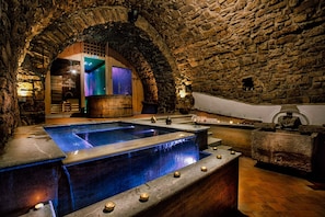A stone-walled spa area with a large rectangular pool and a smaller circular pool, both with water features. - Dimora Storica Giorni (Pignola)