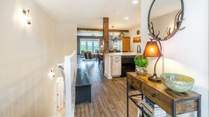 Una cucina moderna con pavimento in legno, un'isola centrale e un'area pranzo con una panca.
