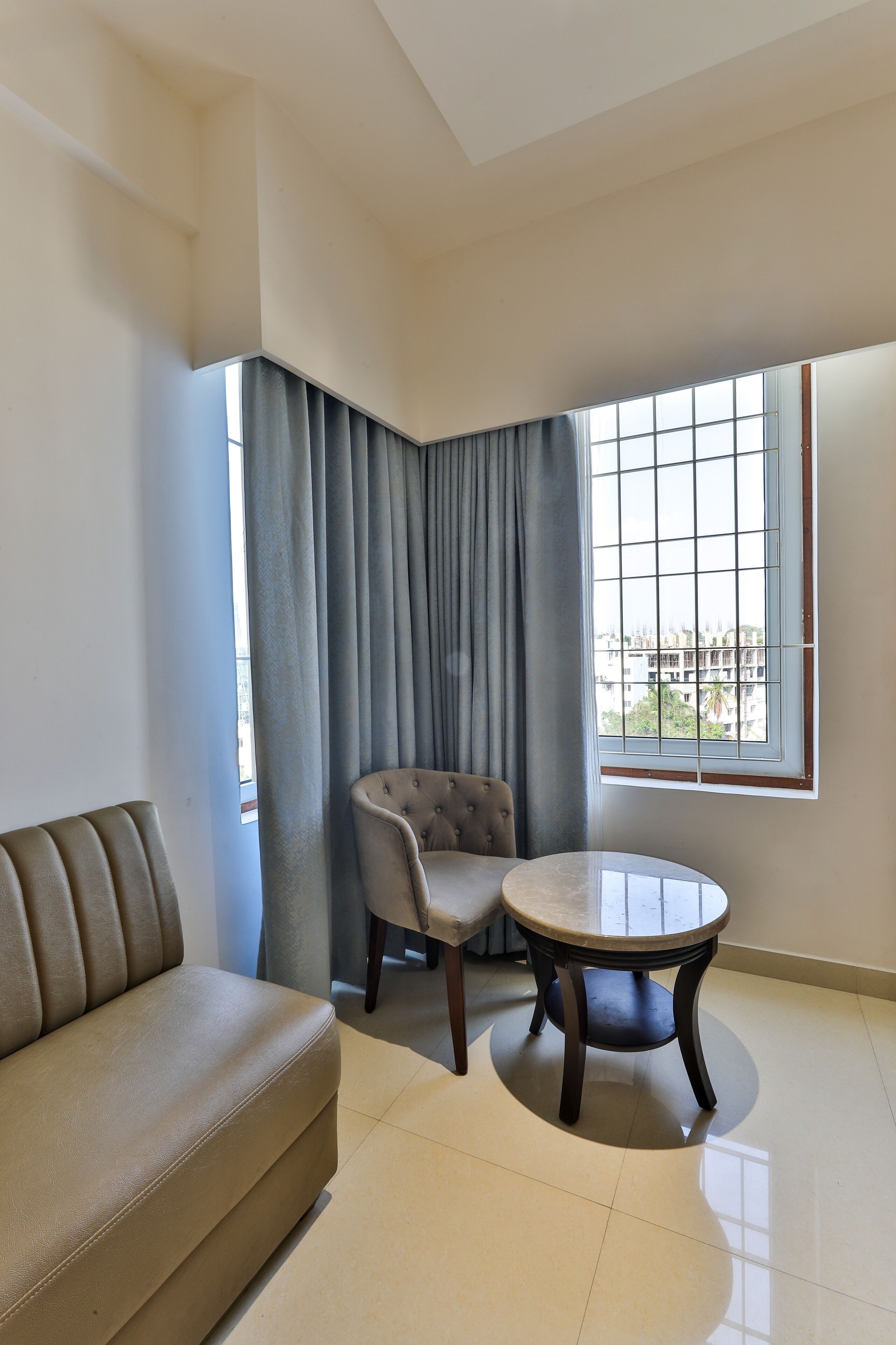 Een moderne woonkamer met een bank, een stoel en een klein rond tafeltje.