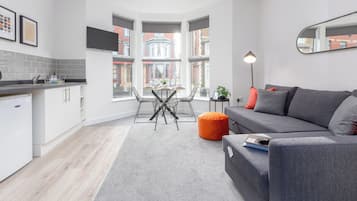 A modern apartment with a kitchen, dining area, and living room.