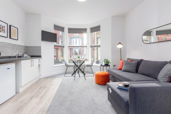 A modern apartment with a kitchen, dining area, and living room.
