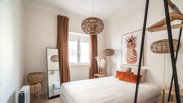 A modern hotel room with a large bed, a standing heater, a mirror, and a window with curtains. - Apartment (Lisboa)