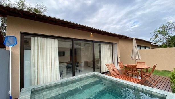 Una piscina con cubierta de madera y mobiliario exterior.