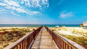 A wooden boardwalk leading to a beach with a sandy shore and a clear blue sky. - Luxury 6 Bdrm Gulf Front w/Dune Walkover, Amazing Gulf Views (Gulf Shores)