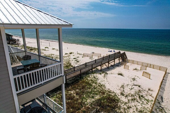 Enjoy ocean views from the balcony, with access to the beach via the wooden deck.