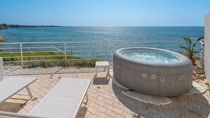 A hot tub on a terrace with a view of the sea. - Cozy sea view rooms with private beach and jacuzzi (Lido di Noto)