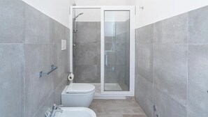A modern bathroom with a shower, toilet, and bidet. - Cozy sea view rooms with private beach and jacuzzi (Lido di Noto)