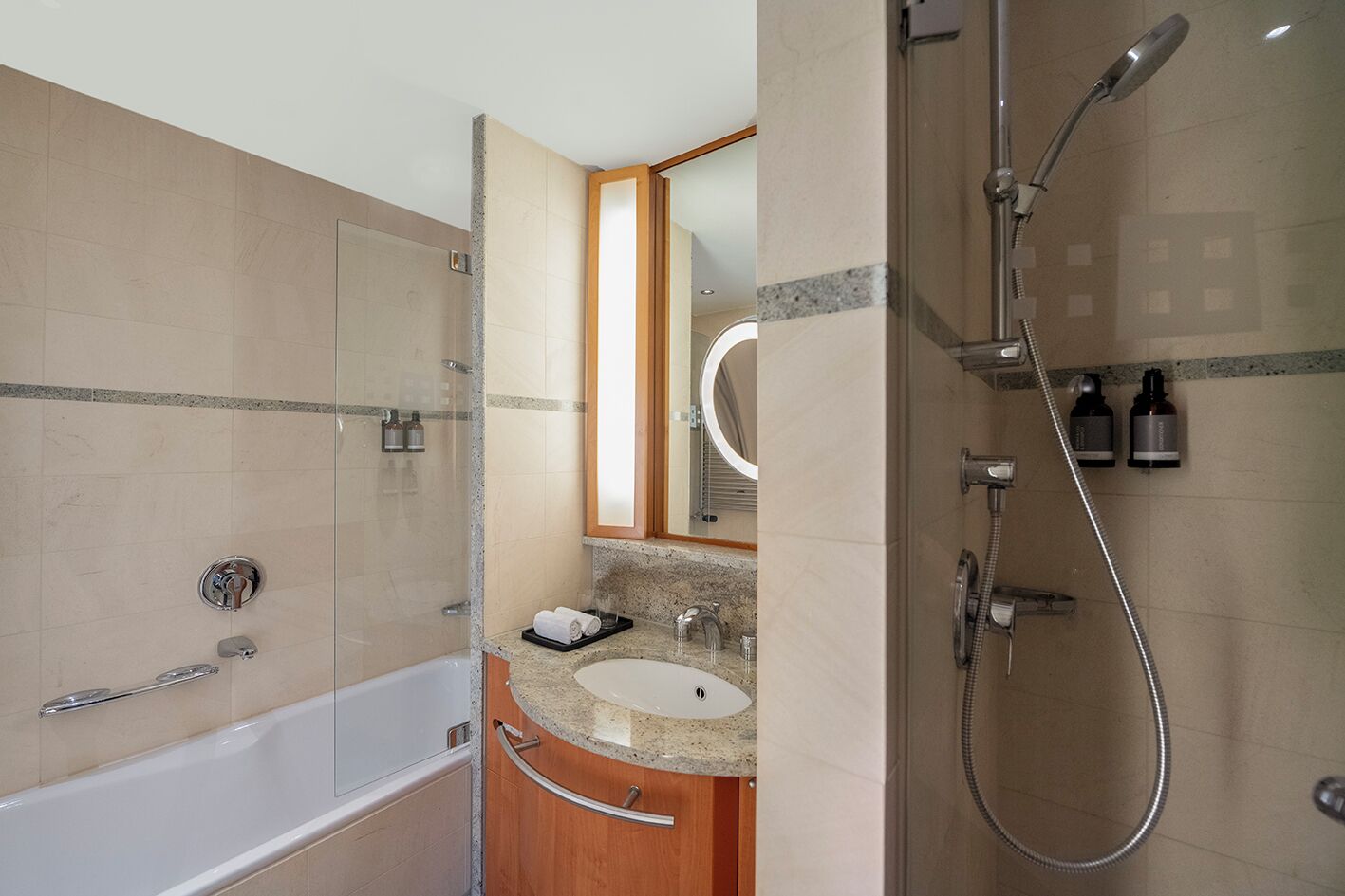 A modern bathroom with a bathtub, a shower, and a vanity with a mirror.