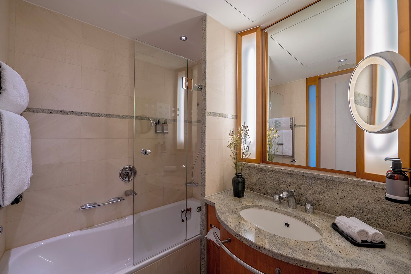 Une salle de bain moderne avec une douche à parois de verre, un meuble-lavabo à deux vasques et un grand miroir.