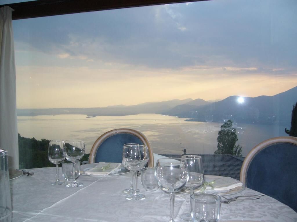 Mesa lista para comer con vistas panorámicas a montañas y un cuerpo de agua.
