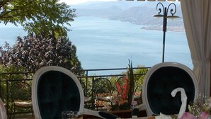 A table set for dining with a view of a lake and mountains.