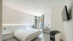 A modern bedroom with a bed, a desk, and a chair.