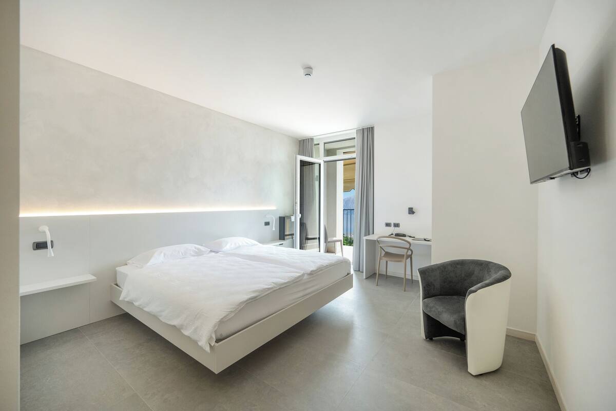 A modern bedroom with a bed, a desk, and a chair.