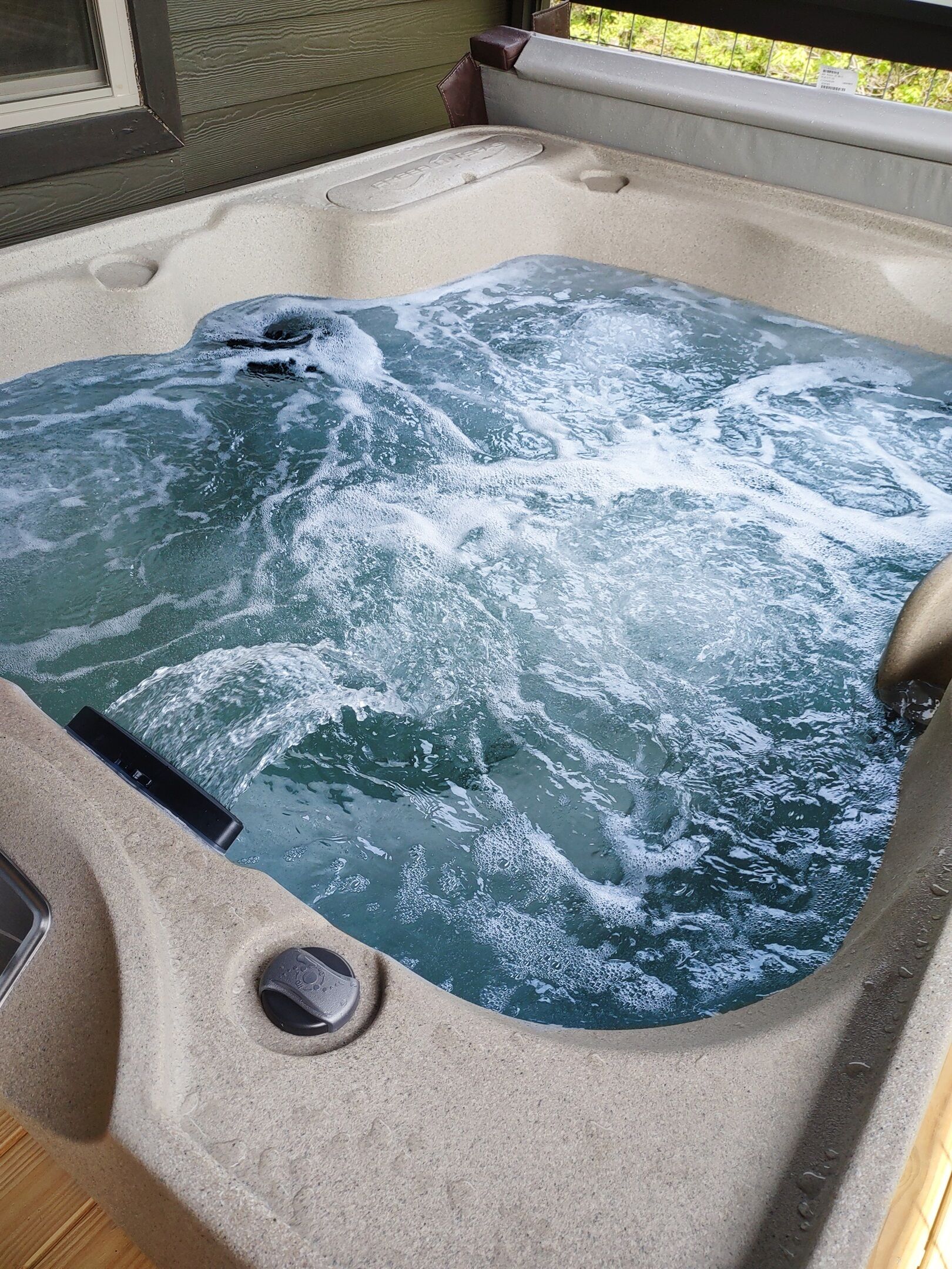 A hot tub with a built-in control panel and a drain.