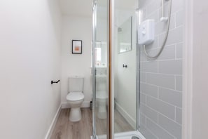 Un bagno moderno con box doccia in vetro, un water e un lavandino.