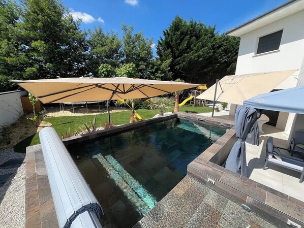 Een buitenzwembad en een verwarmd zwembad