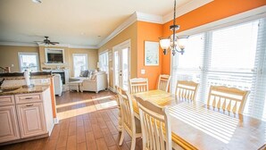 A spacious kitchen with a dining area, wooden cabinets, and a large window providing natural light.