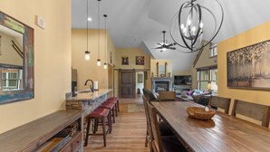 Un'ampia cucina con un'isola grande, sgabelli da bar in legno e illuminazione a sospensione.