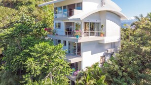 A modern two-story house with a curved roof, large windows, and balconies. - Villa Mar y Sol: 4 Independent Apartments in Quiet, Natural Area w/ wildlife! (Manuel Antonio)
