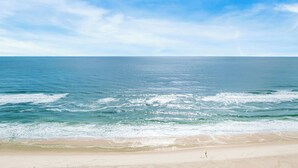 Ein Strand mit klarem, blauem Wasser und sandigem Ufer.