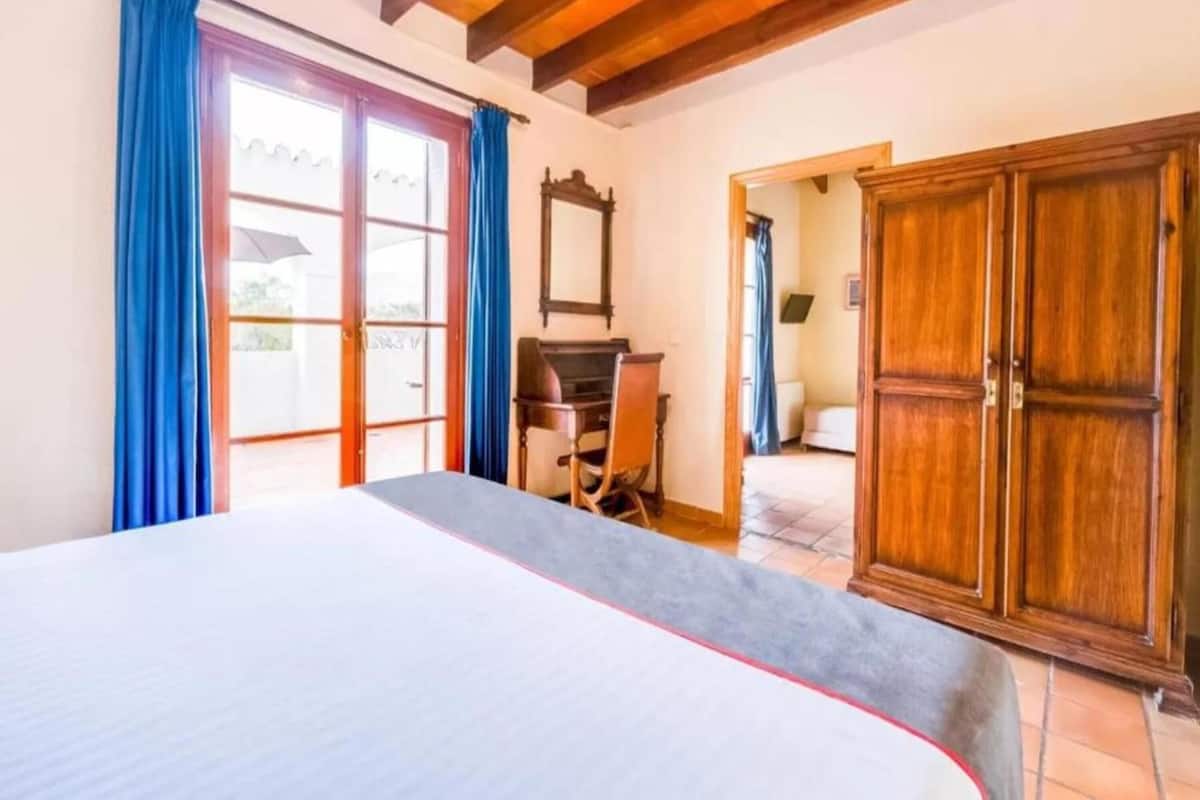 Une chambre à coucher avec un lit, un bureau et une armoire.