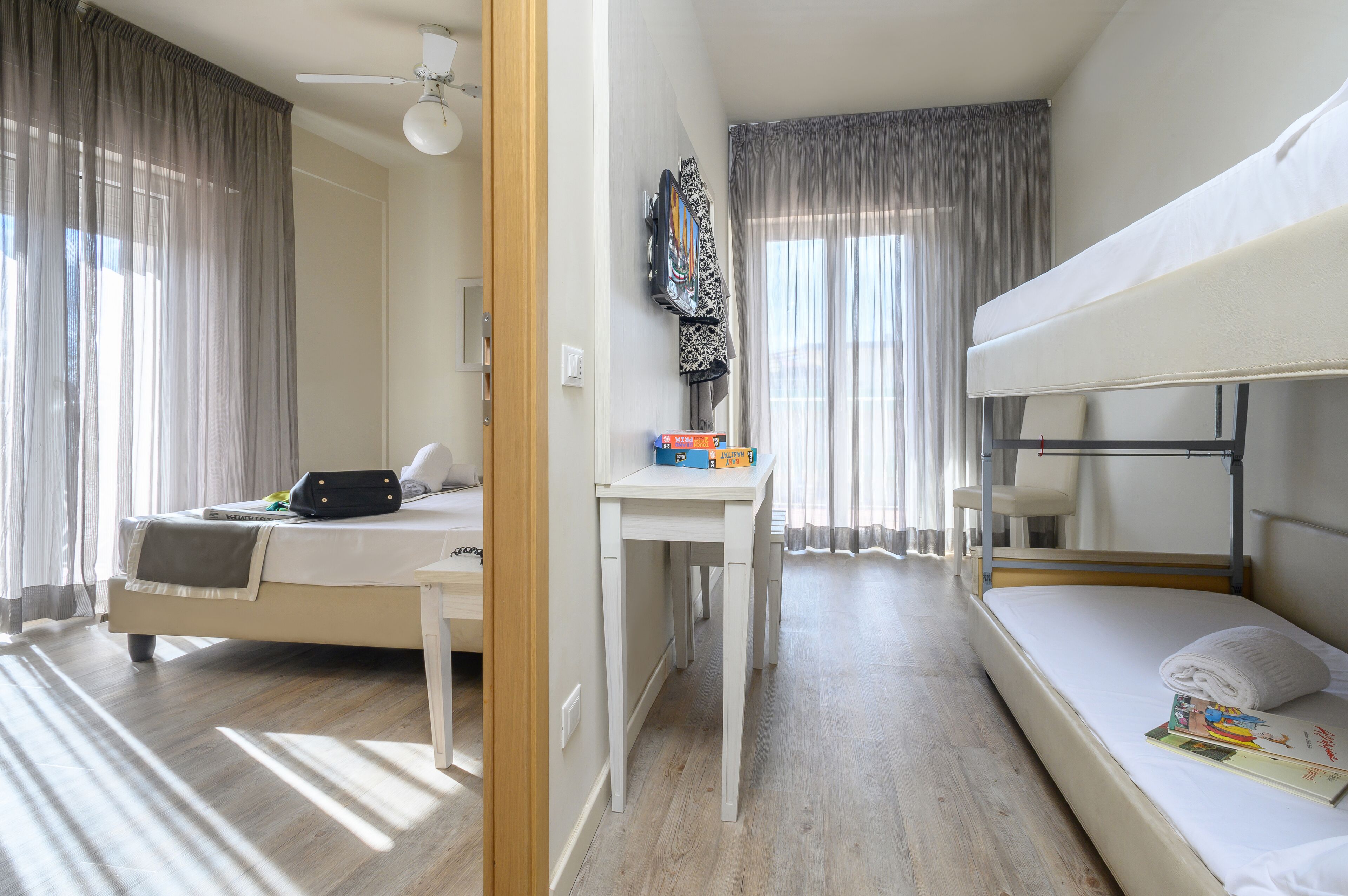 Une chambre avec un lit superposé, un bureau et une chaise.