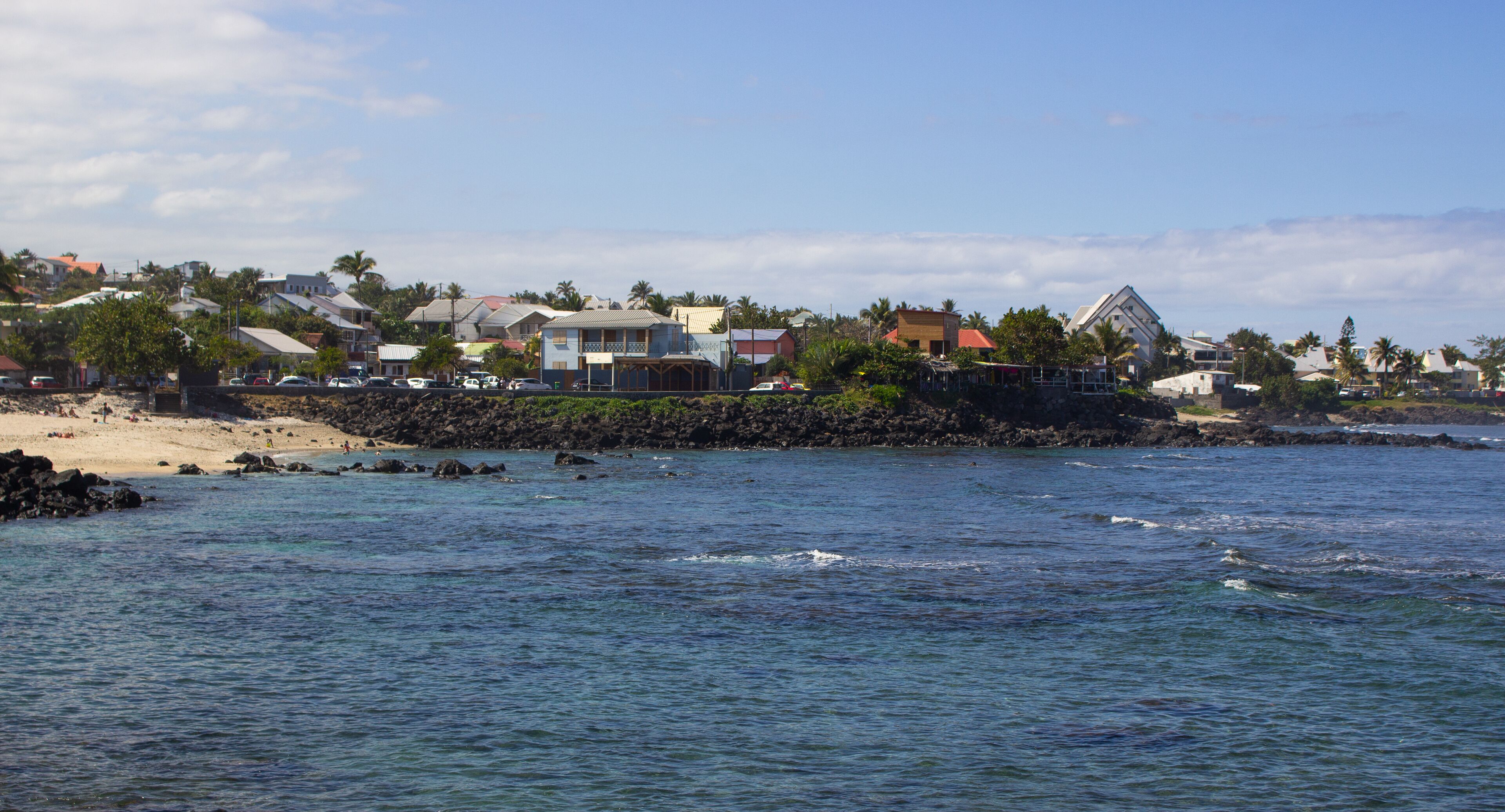 Une ville côtière avec des maisons situées près de la plage et un littoral rocheux.