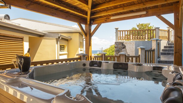A hot tub with a wooden deck and a view of the ocean. - T2 - 66m2 - Résidence Georgette ☆☆☆☆ (SAINT-PIERRE)