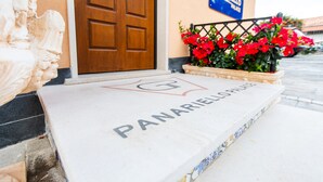 A stone entrance with a wooden door and a sign reading "PANARIELLO PALACE". - Panariello Palace (Agerola)