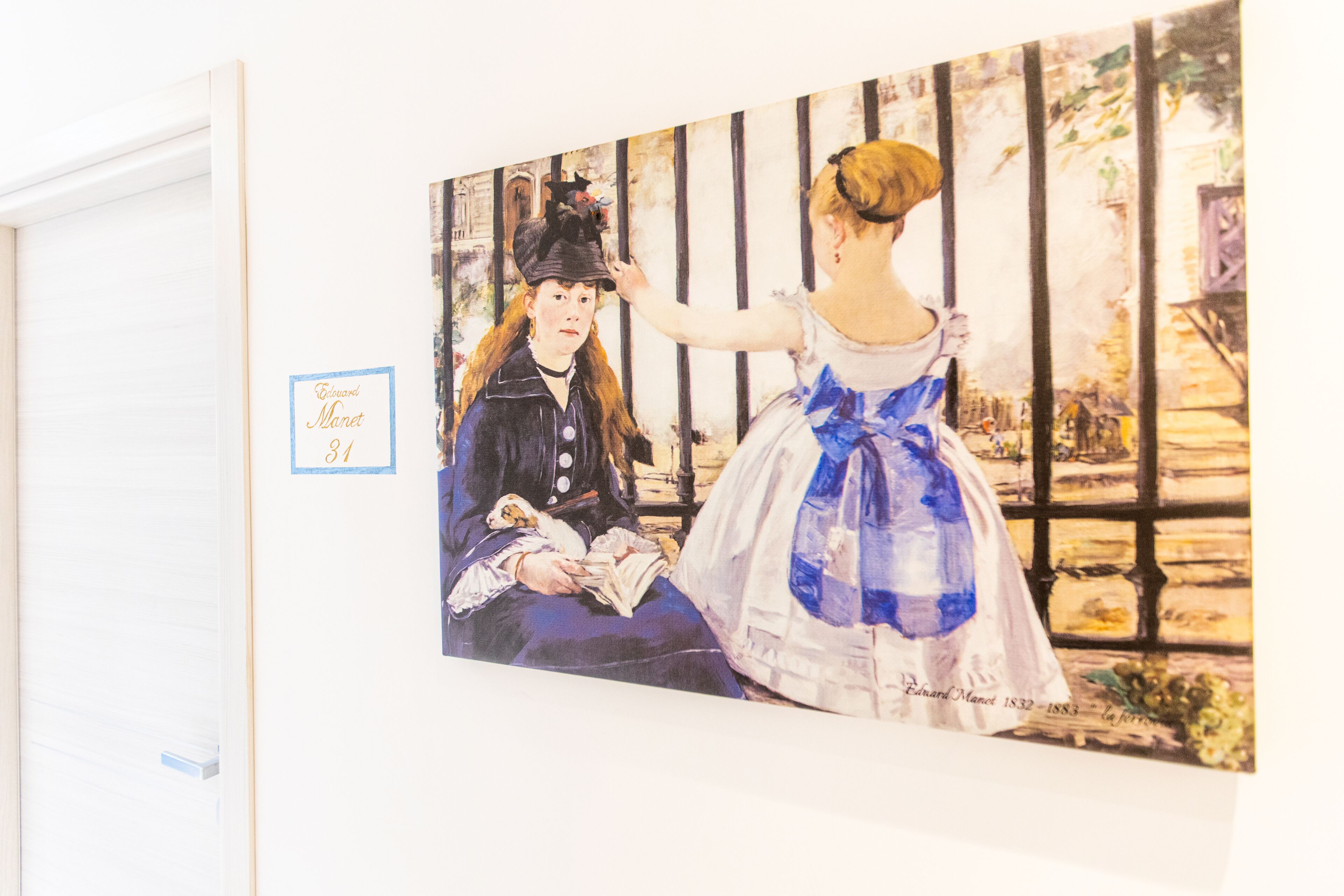 A painting of two women in period attire, one reading a book and the other reaching out to touch the other's hat.