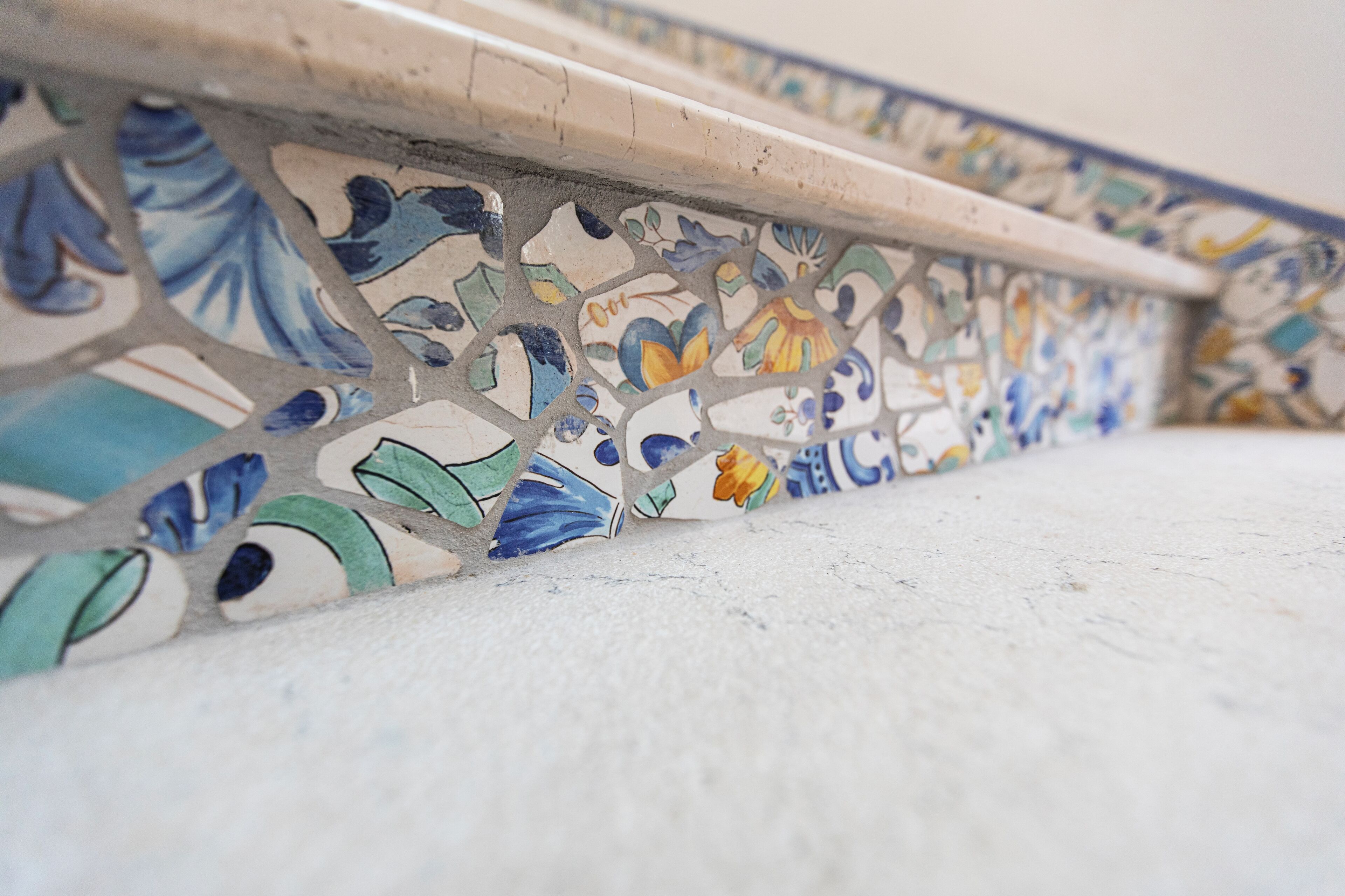 A close-up of a mosaic tile border with floral patterns.