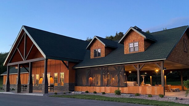 A large, two-story house with a covered porch and a landscaped front yard. - Country Cottage Finger Lakes Region Destination Getaway (LaFayette)