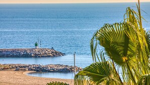 Una spiaggia con un molo roccioso e un faro.