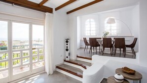 A modern dining area with a staircase leading to a balcony. - L168 Cabopino (Marbella)