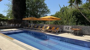 Piscina a l'aire lliure, para-sols i gandules