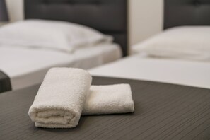 A neatly folded white towel on a dark wooden table in a hotel room. - NEW Villa Dora - Apartment 1 "Green" with terrace and barbecue (Pula)
