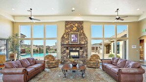 A spacious lobby with a stone fireplace, leather sofas, and large windows offering views of a pool and landscape. - Pebble Beach Oasis, 2 rentals combined- across the street from each other! Sleep (Washington)
