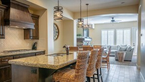 A kitchen with a central island, dark wooden cabinets, and a modern pendant light. - Pebble Beach Oasis, 2 rentals combined- across the street from each other! Sleep (Washington)