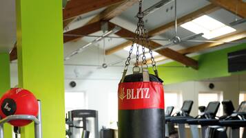 Un gimnasio con un saco de boxeo, pelotas de ejercicio y equipo cardiovascular.