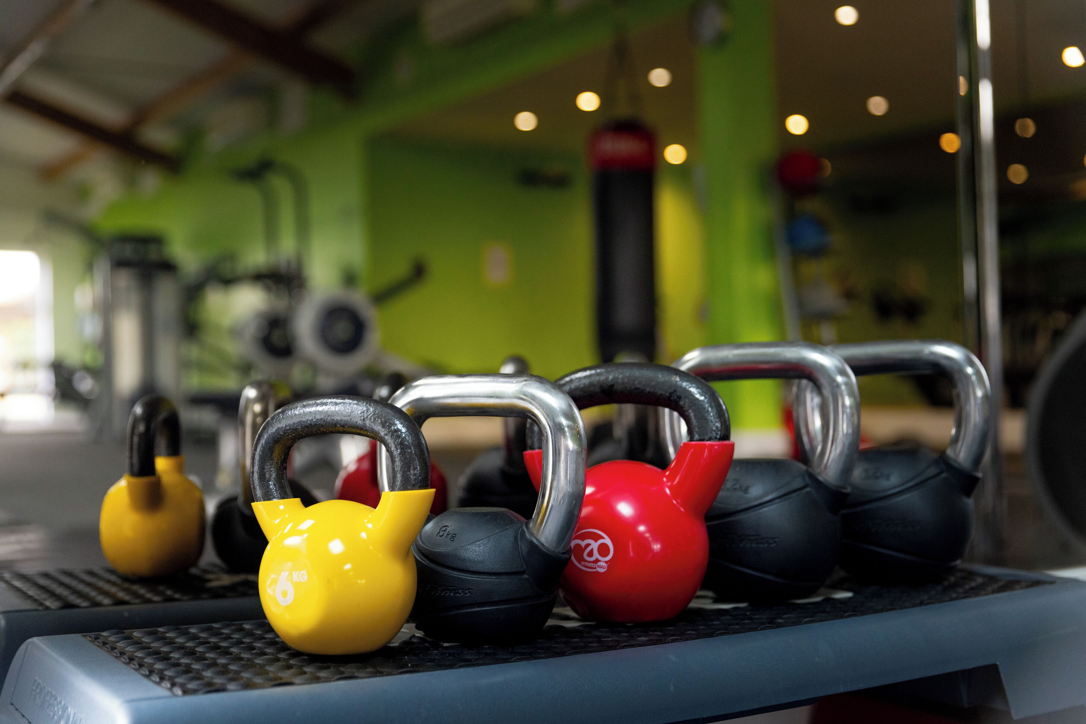 A gym with kettlebells arranged on a rack.