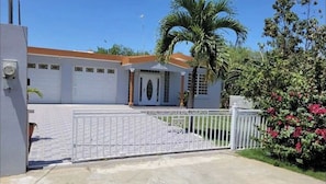 Stunning gated entrance with a charming white picket fence and a beautifully manicured lawn.