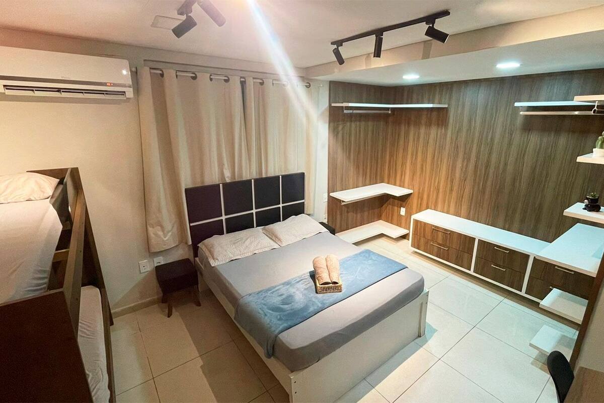 A modern bedroom with a bed, bedside tables, a wardrobe, and a built-in bench.
