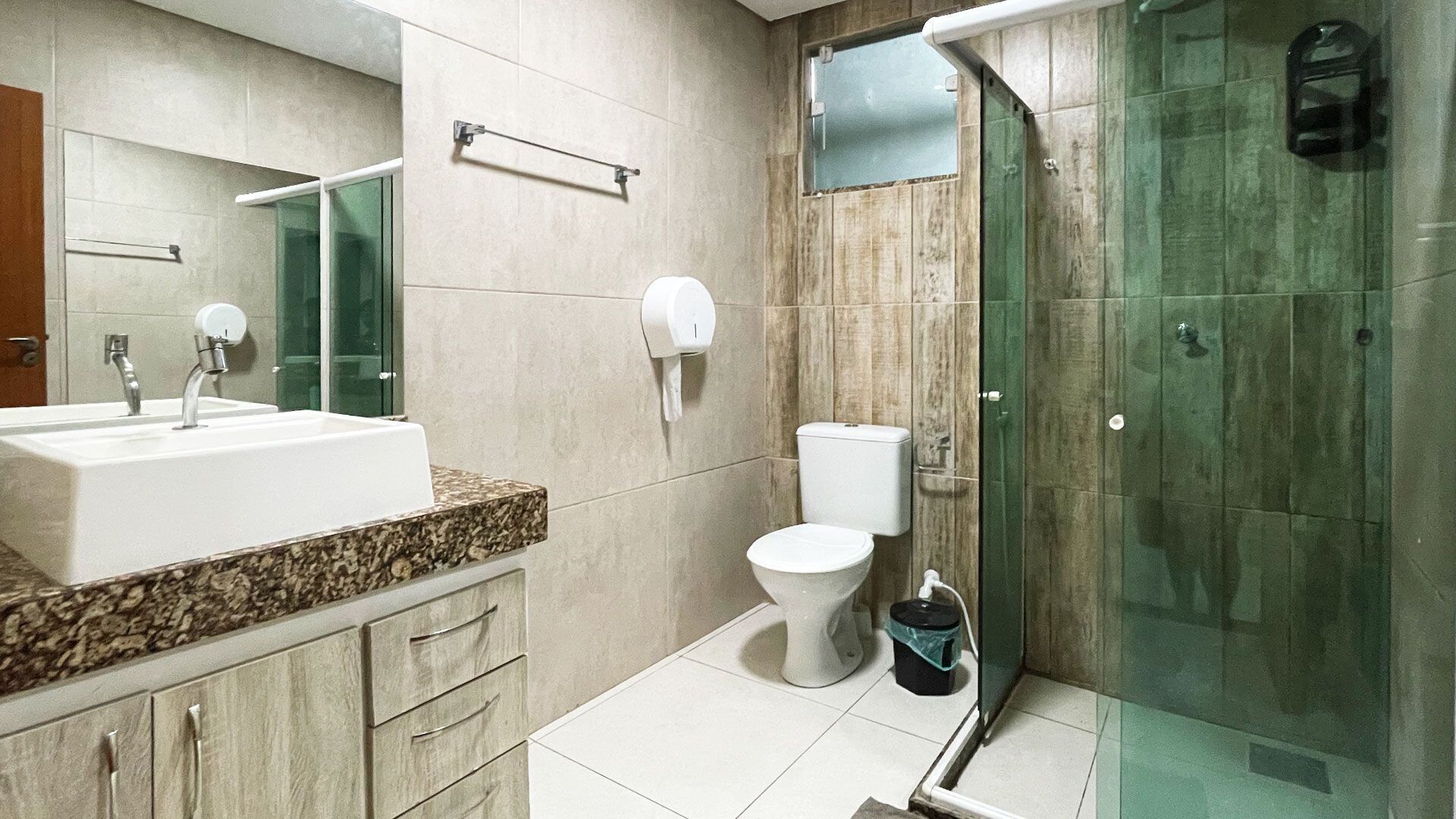 A modern bathroom with a sink, toilet, and glass shower enclosure.
