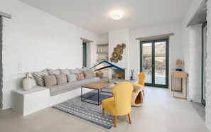 A modern living room with a sofa, yellow chair, and a fireplace.